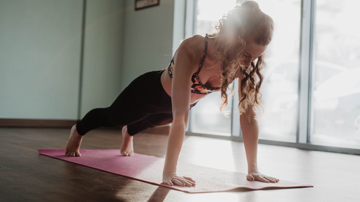 woman in black tank top and black leggings doing yoga